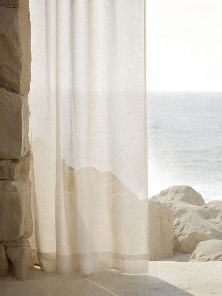 Sheer curtain over a coastal view